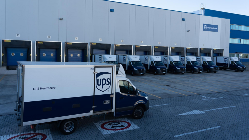 UPS pilots giving the thumbs up as temperature-controlled COVID-19 vaccine shipments are loaded onto a plane for transportation.